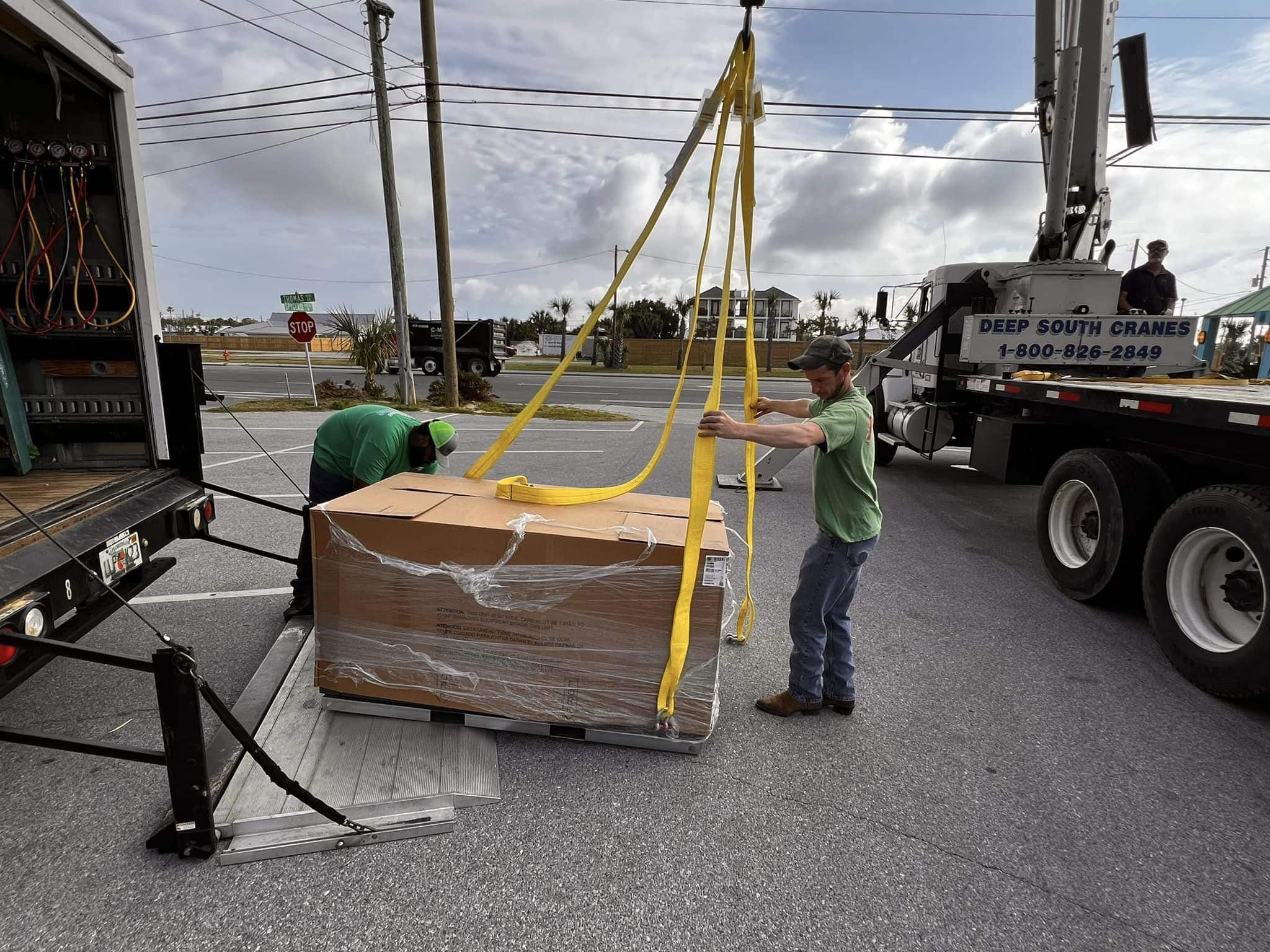 Pat Green Heating & Cooling technicians loading a new HVAC system into a truck for installation